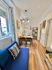 uma sala de estar com um sofá azul e uma mesa em Flat Graça 48 em Lisboa