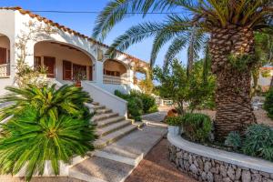 una casa con una palma e scale di Villa Cas Sucrer by Villa Plus a Binibeca