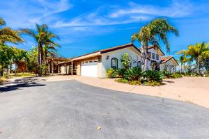 a house with a white garage and palm trees at Alta Vista Villa in Vista