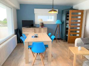 uma cozinha e sala de estar com mesa e cadeiras em Appartement 2 chambres avec superbe vue mer sur la plage de Trestrignel à PERROS-GUIREC - Réf 834 em Perros-Guirec