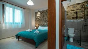 a bedroom with a bed and a shower and a toilet at Akratos House in Kastrákion