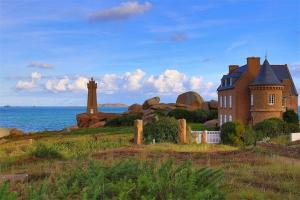 une grande maison sur un champ à côté de l'océan dans l'établissement Appartement 3 étoiles avec belle vue sur mer à PERROS-GUIREC - ref 835, à Perros-Guirec