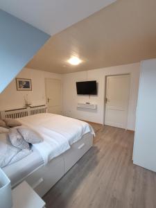 a bedroom with a large bed and a flat screen tv at LütjeFöhr in Alkersum