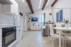 a kitchen and living room with a table and chairs at Coperta Retreat! Near Estense Castle in Ferrara