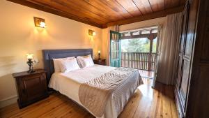 a bedroom with a bed with a wooden ceiling and a window at Quinta do Burgo - Nature Hotel in Amares +72 photos