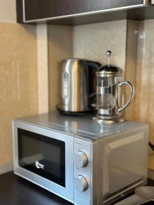 a microwave oven with a coffee pot on top of it at Villa Luisanna Free Parking in Vlorë