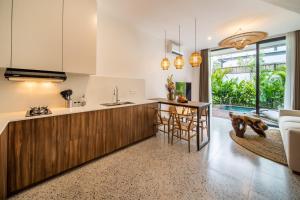 an open kitchen with a counter and a dining room at Sunny Village Berawa in Canggu