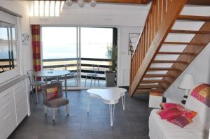 un soggiorno con scala, tavolo e sedie di Appartement belle vue sur mer 3 étoiles à PERROS-GUIREC - ref 836 a Perros-Guirec