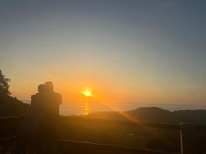 a couple standing in front of a sunset at Samai Lodge Holistic Living in Olón