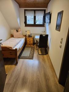 a bedroom with a bed and a television in it at Am Wehrastrand Einzelappartment in Todtmoos