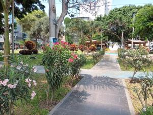 Una pasarela en un parque con flores y árboles en Le Saint-Etienne, en Trujillo