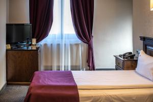 um quarto de hotel com uma cama e uma janela em Pension Korona em Sibiu