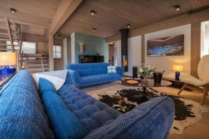 a living room with blue furniture and a blue couch at Chalet Ours Rouge - OVO Network in Le Grand-Bornand