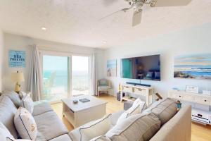 a living room with a couch and a tv at Sea Forever in Kure Beach