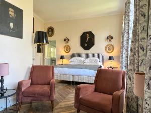 a bedroom with a bed and two chairs at Le Clos Saluces in Avignon
