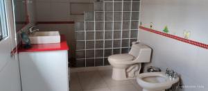 een kleine badkamer met een toilet en een wastafel bij Quinta imperio del sol in Latacunga