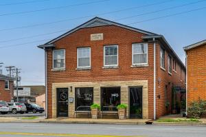 a red brick building with windows on a street at Chic Elizabethtown Apartment Walk to Downtown! in Elizabethtown