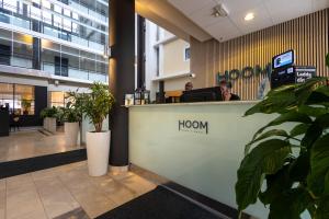 a man sitting at a reception desk in a lobby at HOOM Park & Hotel in Solna