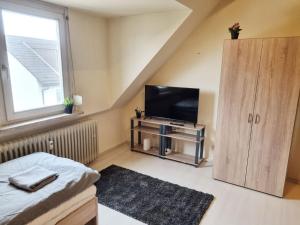a living room with a television and a small cabinet at 3-room Apartment in Offenbach in Bieber
