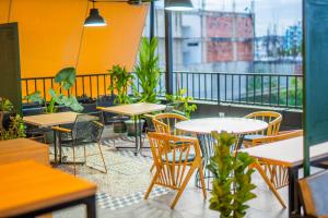 a restaurant with tables and chairs and a balcony at MODERNO Caobos Coliving in Cúcuta