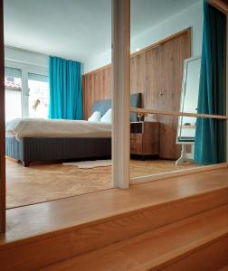 - une chambre avec un lit doté de rideaux bleus et d'un miroir dans l'établissement Old-timer, à Varna
