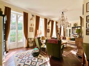 a living room with a couch and a chandelier at Le Clos Saluces in Avignon