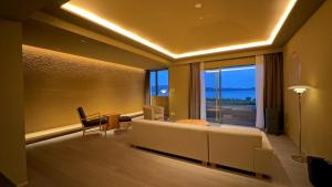 a living room with a couch and a large window at Hotel Anaga in Minamiawaji