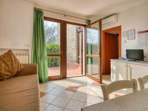 salon z kanapą i przesuwnymi szklanymi drzwiami w obiekcie Golf Residenza w mieście Peschiera del Garda
