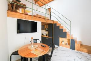 een kleine eetkamer met een tafel en een tv bij Macário Cosy Loft in Porto