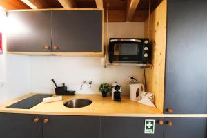 een keuken met een wastafel en een magnetron bij Macário Cosy Loft in Porto