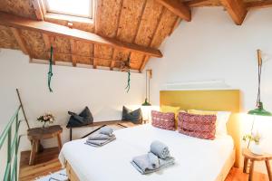 een slaapkamer met een groot wit bed en houten plafonds bij Macário Cosy Loft in Porto