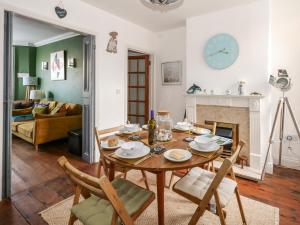 a dining room with a table and chairs and a fireplace at Monaloe in Weymouth