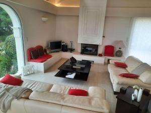 een woonkamer met twee banken en een open haard bij VILLA VUE MER in Pietrosella