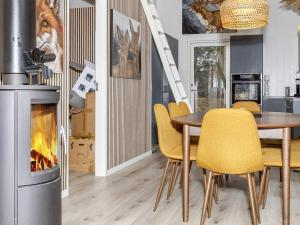 een eetkamer met een open haard en een tafel en stoelen bij Holiday home Aars III in Års