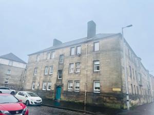 a large brick building with cars parked in front of it at Stylish 2-Bed Apartment in Greenock - Sleeps 6 in Greenock