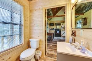 a bathroom with a toilet and a sink and a mirror at Waterfront Marksville Studio with Dock! in Marksville