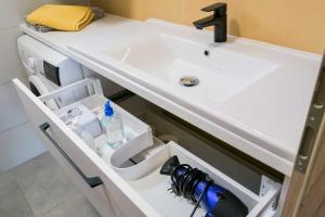 a bathroom vanity with a sink with a bottle of water at EMMY Ház in Badacsonytomaj