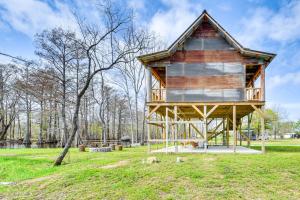 a large wooden building in a field with trees at Waterfront Marksville Studio with Dock! in Marksville