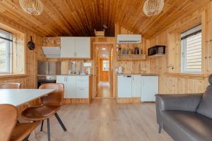 a kitchen and living room in a tiny house at Lítlastova - A Charming Boathouse Getaway in Hvalvík