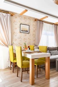 une salle à manger avec une table et des chaises jaunes dans l'établissement Loi Suite, à Antalya