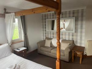 um quarto com uma cama, uma cama e uma cadeira em Hazeldene Hotel em Gretna Green