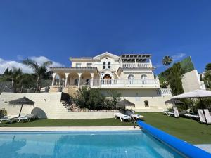 a large house with a swimming pool in front of it at Malagasuite Villa Moriana in Mijas