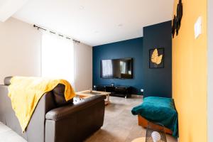 - un salon avec un canapé et un mur bleu dans l'établissement Maison au calme * parking privé * wifi, à Villemandeur