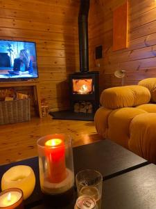 sala de estar con chimenea y mesa con velas en Large Luxury Log Cabin Getaway, en Ballyconnell