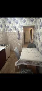 1 dormitorio con 1 cama, 2 sillas y lavamanos en Квартира en Shymkent