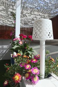 una sedia bianca seduta accanto a un mazzo di fiori di Darahome a Cunit