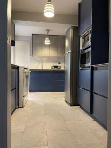 a kitchen with blue cabinets and stainless steel appliances at Familia Segovia Tejada in Quito
