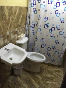 La salle de bains est pourvue d'un lavabo, de toilettes et d'un rideau de douche. dans l'établissement La hermosa hotel, à Santa Cruz de Barahona