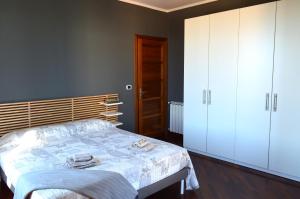 1 dormitorio con 1 cama y armarios blancos en Clementina sunset apartment, en Fiumicino