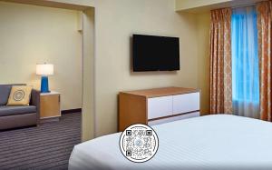 a hotel room with a bed and a television at Sonesta Simply Suites Memphis East Poplar Pike in Memphis